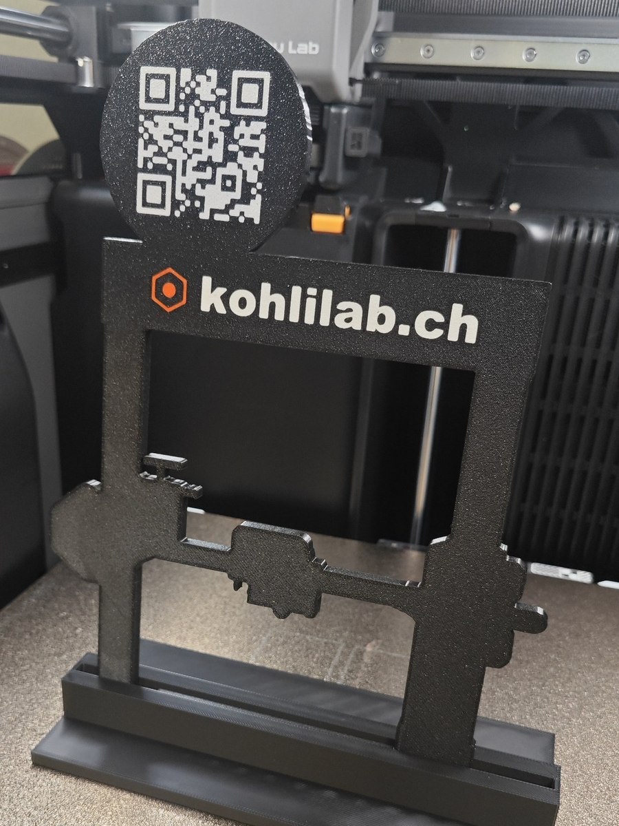 Gedruckter KohliLab-Tischaufsteller mit QR-Scheibe und Schriftzug kohlilab.ch, frisch aus dem Drucker